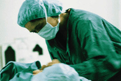 Médico interviniendo paciente en quirófano