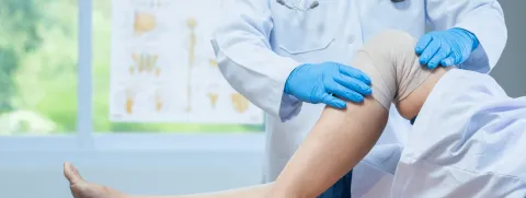 Cirugía de meniscos. Médico inspeccionando la rodilla del paciente