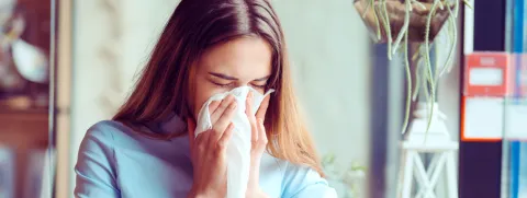 Mujer con pañuelo en la nariz con alergia primaveral. Clínica Santa María