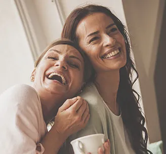 Dos mujeres riendo. Cáncer cervicouterino. Clínica Santa María.
