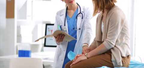 Mujer joven en consultorio con doctora