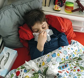 Niño enfermo en la cama.