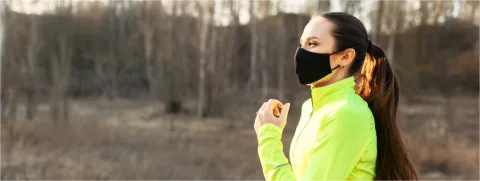 Mujer con cubreboca corriendo por el parque, Covid19