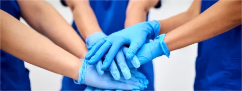 Manos de médicos uniéndose. Clínica Santa María.