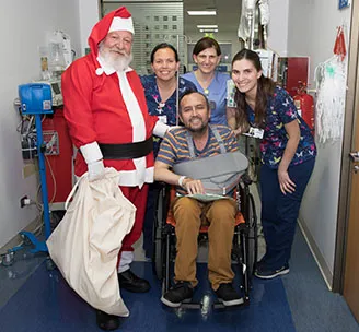 Viejito pascuero celebrando navidad con pacientes de Clínica Santa María.