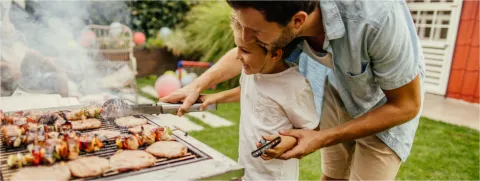 Papá cocinando con su hijo al aire libre