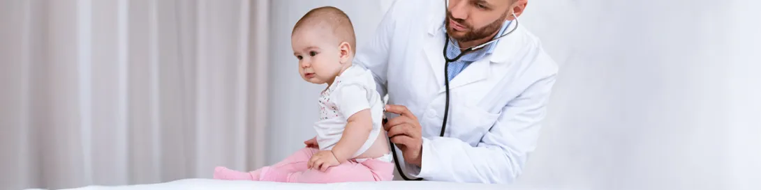 Médico auscultando a bebé. Especialidad Broncopulmonar Infantil.