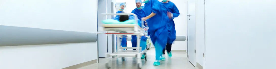 Paciente llevado en camilla por pasillo de clínica. Especialidad Cirugía de Urgencias