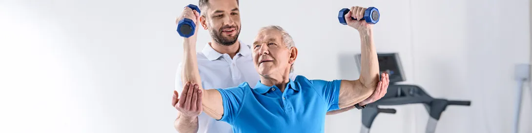 Hombre mayor haciendo rehabilitación con pesas. Especialidad Fisiatría