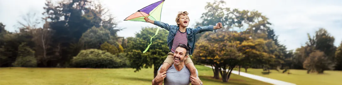 Papá con su hijo corriendo con barrilete