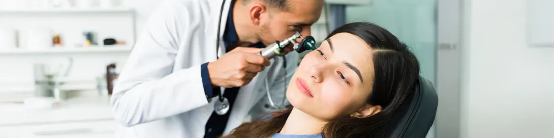 Médico examinando oído de una mujer