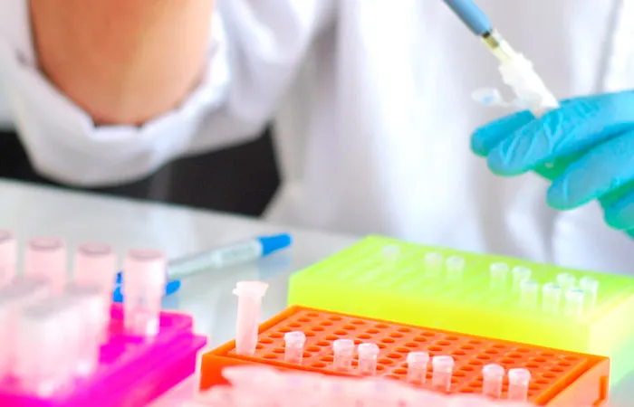 Manos con guantes de profesional trabajando en laboratorio